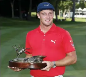  ?? CHARLIE NEIBERGALL — THE ASSOCIATED PRESS ?? FILE - In this July 16, 2017, file photo, Bryson DeChambeau celebrates with the trophy after winning the John Deere Classic golf tournament, at TPC Deere Run in Silvis, Ill.