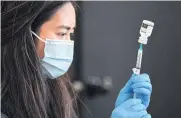  ?? AFP ?? A Covid-19 vaccine is prepared for administra­tion at the Union Station in Los Angeles, California.