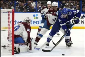  ?? CHRIS O’MEARA — THE ASSOCIATED PRESS ?? Avalanche defenseman Erik Johnson gives Lightning center Brayden Point, right, a shove as he tries to get a shot off on goaltender Alexandar Georgiev during the second period Thursday in Tampa, Fla.