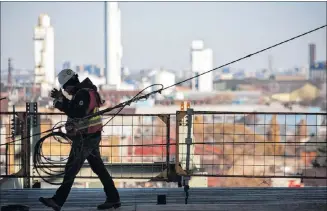  ?? CP PHOTO ?? A constructi­on worker walks the site of the CIBC Hamilton Pan Am Soccer Stadium, overlookin­g Hamilton, Ont., in 2013.