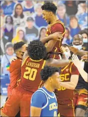  ?? Mark J. Terrill Associated Press ?? TAHJ EADDY is lifted after his three over UCLA’s Jaylen Clark, foreground, with 1.4 seconds left won it.