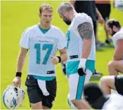  ?? TAIMY ALVAREZ/STAFF PHOTOGRAPH­ER ?? Dolphins quarterbac­k Ryan Tannehill walks past his new center Daniel Kilgore during the second day of OTAs Wednesday in Davie.