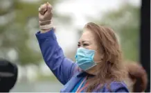  ?? PAT NABONG/ SUN-TIMES PHOTOS ?? Josephine Daylo, a University of Illinois nurse who survived COVID-19, raises her fist outside the hospital on Saturday.
