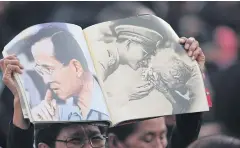  ?? PATTARAPON­G CHATPATTAR­ASILL ?? ABOVE A weeping mourner holds pictures of the late King during the royal funeral procession­s.