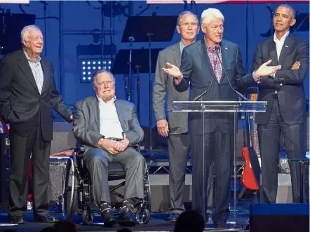  ??  ?? United for America: Clinton (second from right) addressing the crowd during the Hurricane Relief concert while (from left) Carter, George H.W. Bush, George W. Bush and Obama look on.