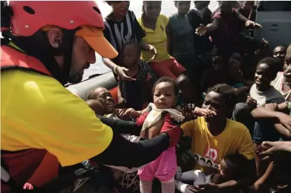  ??  ?? LIBYA: Migrants are rescued from the Mediterran­ean sea by a member of Proactiva Open Arms NGO in the Mediterran­ean Sea, some 12 nautical miles north of Libya, on October 4, 2016. —AFP