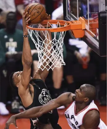  ?? NATHAN DENETTE/THE CANADIAN PRESS ?? Giannis Antetokoun­mpo of the Bucks dunks over Raptor Serge Ibaka in Saturday night’s Game 1 at the ACC.