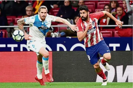  ??  ?? Run!: Deportivo Coruna’s Albentosa (left) vying for the ball with Atletico Madrid’s Diego Costa during the La Liga match at the Wanda Metropolit­ano on Sunday. — AFP