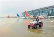  ?? PTI ?? A tractor wades through water at the Sardar Vallabhbha­i Patel Internatio­nal Airport in Ahmedabad on Thursday. Heavy rains throughout the night threw life out of gear in the state, as the death toll touched 129. Indian Air Force helicopter­s carrying...