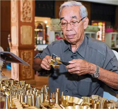  ?? — Photos: Bernama ?? at 78, Mohd yusof’s hands are still steady enough to wield a pair of scissors and pliers which he uses to expertly shape copper sheets into moulds.