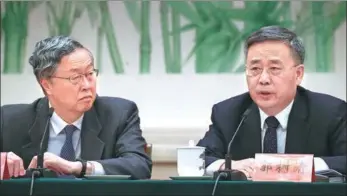  ?? EDMOND TANG / CHINA DAILY ?? Central bank governor Zhou Xiaochuan (left) and Guo Shuqing, chairman of the China Banking Regulatory Commission, at the 19th National Congress of the Communist Party of China on Thursday.