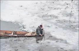  ?? WASEEM ANDRABI/HT ?? A man collects lotus stems from a frozen Nigeen Lake in Srinagar on Monday.