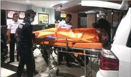  ?? EDI SUDRAJAT/JAWA POS ?? PUTUS ASA: Jenazah Siswandoko dievakuasi petugas ke dalam ambulans Rabu malam (21/2).