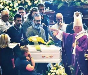  ?? AFP ?? Archbishop of Genoa Cardinal Angelo Bagnasco (right) blesses the coffins during the state funeral of the victims of the Morandi Bridge collapse, in Genoa on Saturday.