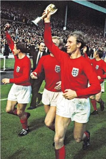  ??  ?? Jack Charlton, with Bobby Moore at his side, holds the trophy up to a delighted Wembley crowd after England’s 1966 World Cup win