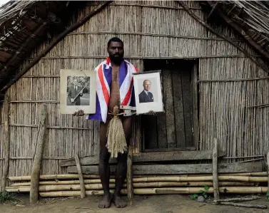  ??  ?? ABOVE: Sikor Nathuan, the current chief, displays the two official portraits sent to the Tannan people by the Duke.