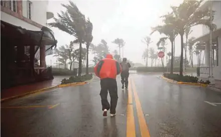  ?? REUTERS PIC ?? People walking in South Beach as Hurricane Irma arrives in Miami Beach, Florida, yesterday.