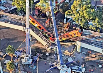  ?? — AP/PTI ?? An aerial view of subway cars dangle at an angle from a collapsed elevated section of the metro, in Mexico City, on Tuesday. The elevated section of Mexico Citys metro collapsed late on Monday killing at least 23 people and injuring at least 79, city officials said.