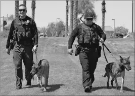  ?? Buy this photo at YumaSun.com PHOTO BY RANDY HOEFT/YUMA SUN ?? YUMA POLICE DEPARTMENT OFFICER Zachary Miner (left) walks with his K-9, Barry, alongside fellow YPD officer Matthew Woen, who walks with his K-9, Mitch. The two K-9s are being retired after joining the force in 2011.