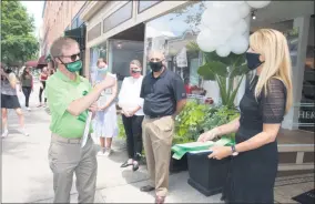  ?? PHOTO PROVIDED BY THE SARATOGA COUNTY CHAMBER OF COMMERCE ?? Toga Heritage founder and CEO Deborah DePasquale interacts with Saratoga County Chamber of Commerce president Todd Shimkus during a ribbon cutting ceremony for the company’s new store location on Broadway in Saratoga Springs.