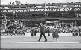  ?? [ALEX BRANDON/THE ASSOCIATED PRESS] ?? President Donald Trump, accompanie­d by first lady Melania Trump, walks along the track before the start of the Daytona 500 auto race at Daytona Internatio­nal Speedway in Daytona Beach, Fla.