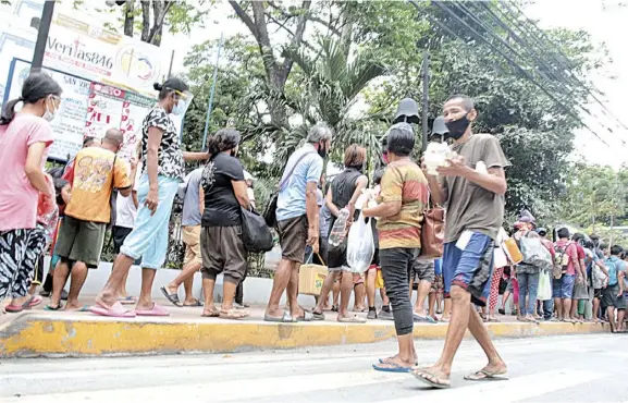  ?? PHOTOGRAPH BY JOEY SANCHEZ MENDOZA FOR THE DAILY TRIBUNE ?? HOMELESS people from different areas in Manila fall in line in a feeding program at Adamson University Saturday.