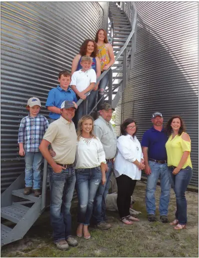  ??  ?? Members of WKW Farms of Swifton operate 3,000 acres of row crops in Jackson County. Three families form the farm partnershi­p. Members of the families, gathered around one of the grain storage bins, include, on the stairs, from top, Madison Walker, Elizabeth Walker, Cagen Walker, Jesse King and Jake King; and front row, from left, Rob Walker, Andrea Walker, Greg King, Laura King, John Walker and Mandy Walker.