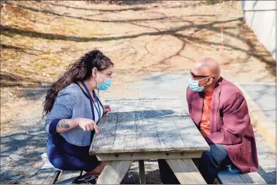  ?? Yehyun Kim / CTMirror.org ?? Carrie Perez, left, talks to a client, Derrick Charles Gray, at the Wheeler Clinic in New Britain. Perez, a peer support specialist whose job includes helping people with drug addiction, supports passage of the “Clean Slate” bill by the state legislatur­e.