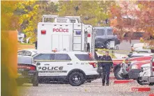  ?? ROBERTO E. ROSALES/JOURNAL ?? An APD officer walks near the scene of a domestic violence call that turned deadly Monday morning at the Aspen apartments in northwest Albuquerqu­e.