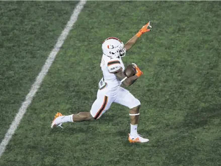  ?? Andy Lyons, Getty Images ?? Jaylan Knighton of the Miami Hurricanes runs for a 75- yard touchdown in the third quarter against the Louisville Cardinals at Cardinal Stadium on Saturday night in the ACC opener.