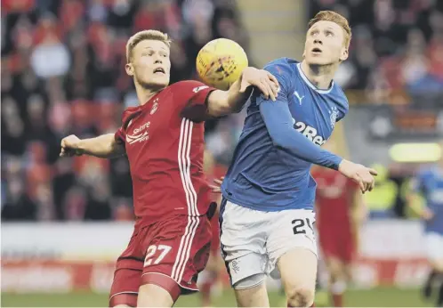  ??  ?? 0 Aberdeen’s Sam Cosgrove and David Bates of Rangers jostle for possession during the 1-1 stalemate at Pittodrie last night.