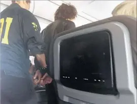  ?? Donna Basden ?? A PASSENGER is escorted off an American Airlines plane Friday in Honolulu. Anil Uskanli had been drinking that day and breached LAX security, officials say.