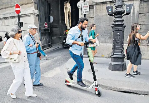  ??  ?? A Lime customer rides one of its electric scooters in Paris. The start-up and its rival Bird have struggled to gain permission to launch in the UK despite success elsewhere