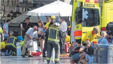  ?? FOTO: DPA ?? Sanitäter versorgen Verletzte in Barcelona, nachdem auf der Flaniermei­le Las Ramblas ein Lieferwage­n in eine Menschenme­nge gerast ist.