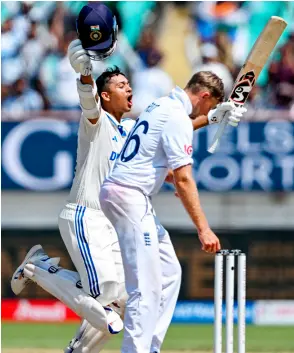 ?? — AFP photo ?? Jaiswal (left) celebrates after scoring a double century (200 runs) during the fourth day of the third Test cricket match between India and England at the Niranjan Shah Stadium in Rajkot.