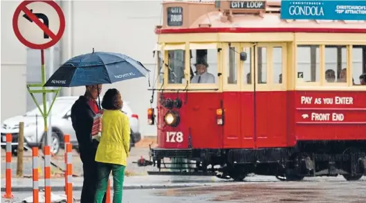  ?? Photo: JOHN KIRK-ANDERSON/FAIRFAX NZ ?? Summer shower: Visitors in Christchur­ch’s central city were undeterred by the cool, rainy conditions yesterday afternoon after a sunny and warm Christmas Eve and morning.