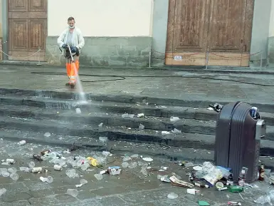  ??  ?? Un tappeto di bottiglie, bicchieri e rifiuti ieri mattina sul sagrato di Santo Spirito (foto di una residente)