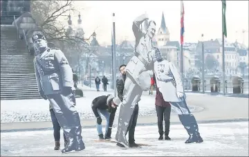  ??  ?? Activists of Avaaz civic organizati­on set up three-metre-high images of former far-right leaders (from left) Mussolini, Hitler and Pétain in front of the town’s historic Deutches Eck statue in Koblenz, western Germany, to protest against the congress...