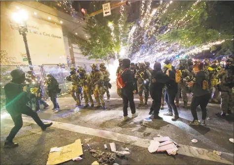  ?? Marcio Jose Sanchez / Associated Press ?? Federal officers advance on demonstrat­ors during a Black Lives Matter protest at the Mark O. Hatfield United States Courthouse on Saturday in Portland, Ore.