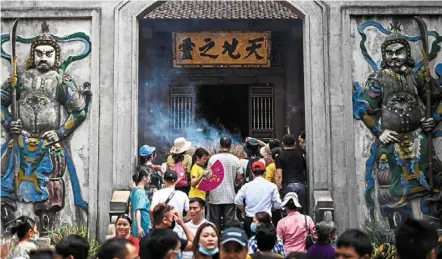  ?? — AFP ?? Yearly event: devotees burning incense sticks at the temple atop the Nghia linh mountain during the hung Kings festival in phu Tho province.