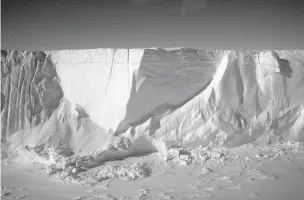  ?? JONATHAN CORUM/THE NEW YORK TIMES ?? The edge of multiple-mile-long iceberg that broke off of the Ross Ice Shelf and became grounded in McMurdo Sound in Antarctica, in 2017. Scientists are racing to understand what is happening to the ice shelf as the planet warms around it.