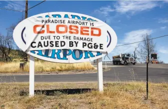  ??  ?? A banner blames PG&E for the Paradise Airport being closed. The law signed by Gov. Gavin Newsom will shield utilities from some liability and establish a fund for fire victims.