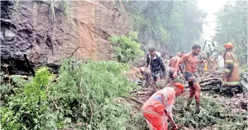  ?? — Reuters photos ?? People and rescue workers are seen at the site of a mudslide after heavy rains.