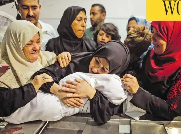  ?? MAHMUD HAMS / AFP / GETTY IMAGES ?? The mother of Leila al-Ghandour, an eight-month-old Palestinia­n baby who died during clashes in East Gaza on Monday, cradles her body at the morgue of al-Shifa hospital in Gaza City.