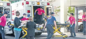  ??  ?? One of the wounded is wheeled into casualty at a hospital in Roseburg, Oregon, after the shooting yesterday at Umpqua Community College, right