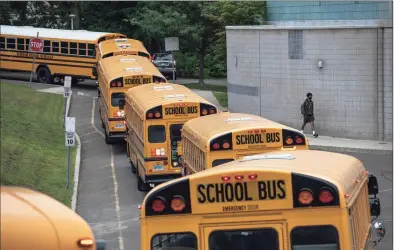  ?? John Moore / Getty Images ?? Busses depart after dropping off students at Rippowam Middle School on Sept. 14 in Stamford. Most students there are taking part in a hybrid model, where they attend in-school classes every other day and distance learn the rest. More than 20 percent of students in the Stamford Public Schools district are enrolled in the distance learning option only, due to coronaviru­s concerns.