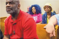  ?? JAKE MAY/THE FLINT JOURNAL ?? Flint, Mich., residents Arthur Woodson, Barbie Biggs and Claire McClinton listen in Genesee County Court Monday as Judge David J. Goggins announces manslaught­er charges against the state health director.