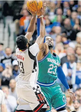  ??  ?? The Rockets’ James Harden, left, goes up for a shot against the Mavericks.