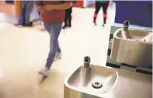  ?? Lea Suzuki / The Chronicle ?? Students walk by a water fountain cleared for use at Internatio­nal High School, one of the schools where lead was found.