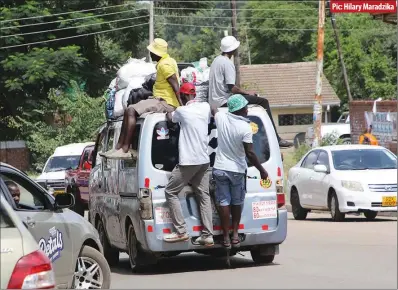  ?? ?? Touts sit precarious­ly on top of a moving kombi at corner Ardbennie and First roads in Mbare,Harare,recently
Pic: Hilary Maradzika